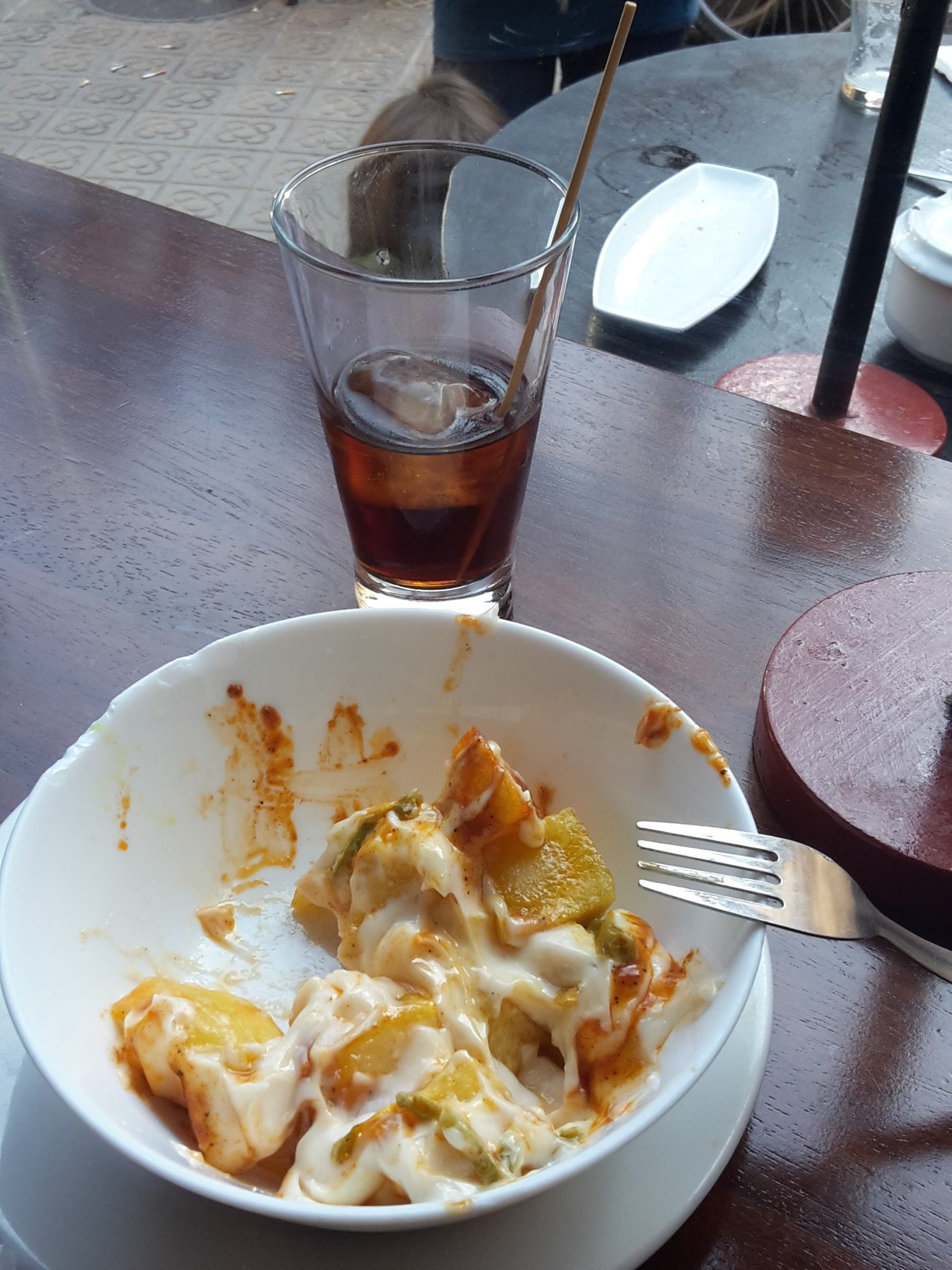 Glass of vermut and half eaten patatas bravas